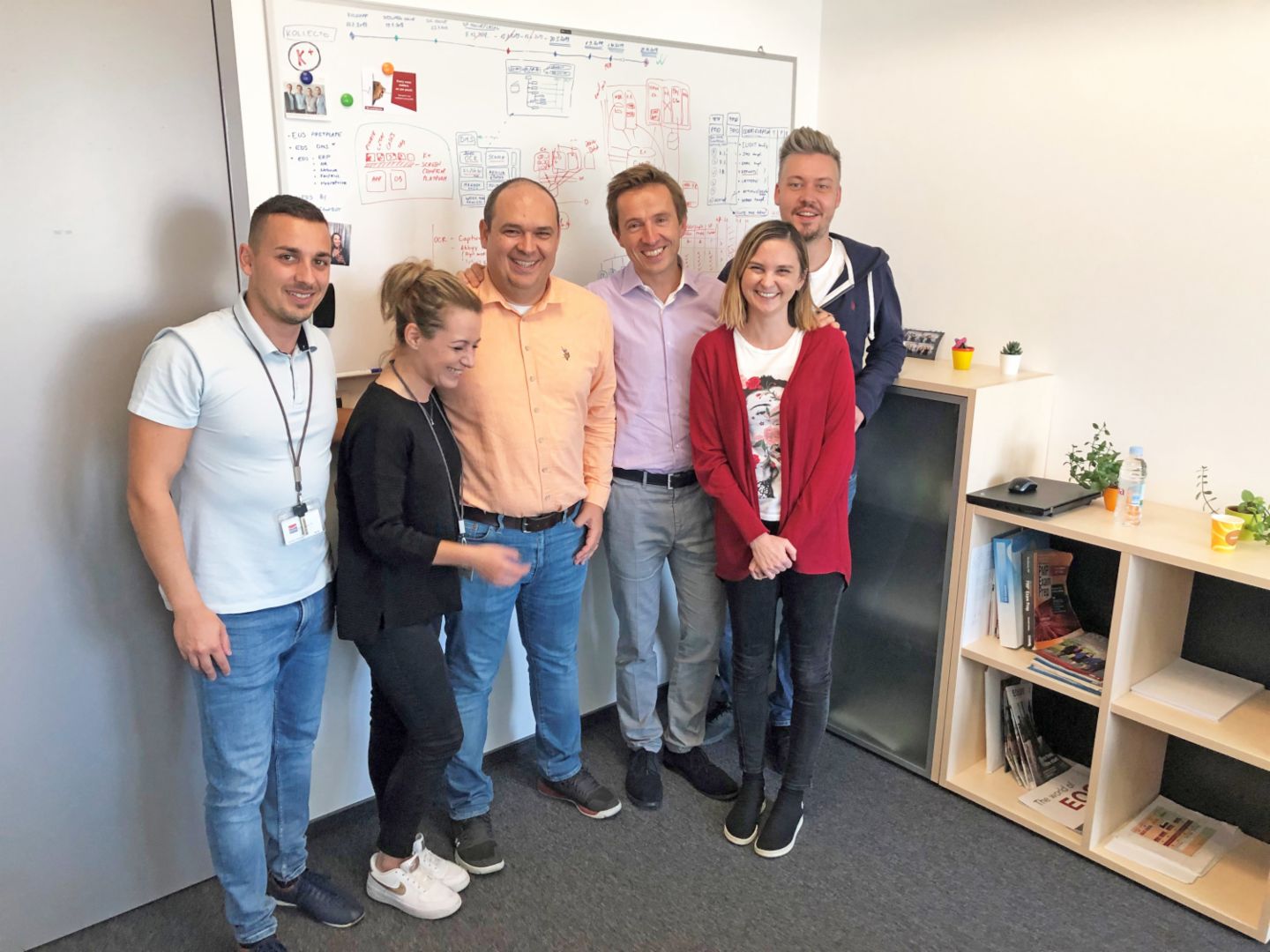 Two women and two men in front of a whiteboard