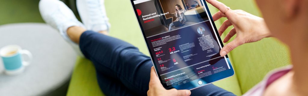 EOS ASR: Imaginea arată o tânără care ține o tabletă și consultă pe aceasta Raportul anual de sustenabilitate al EOS.