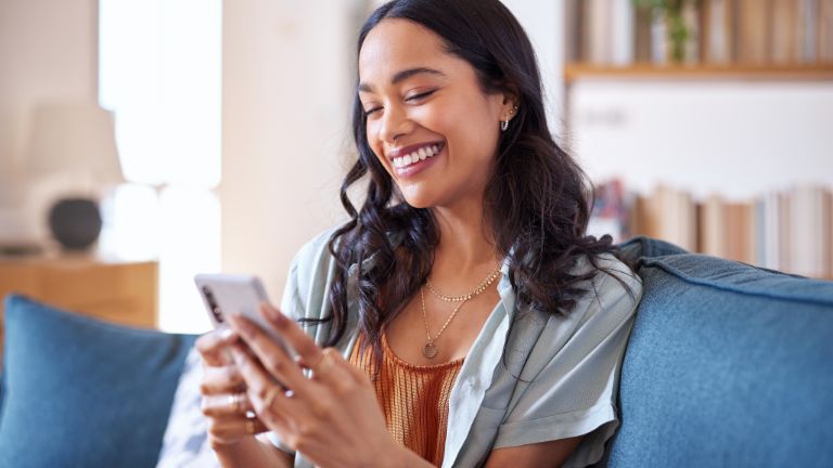 Woman sitting on a sofa and using smartphone