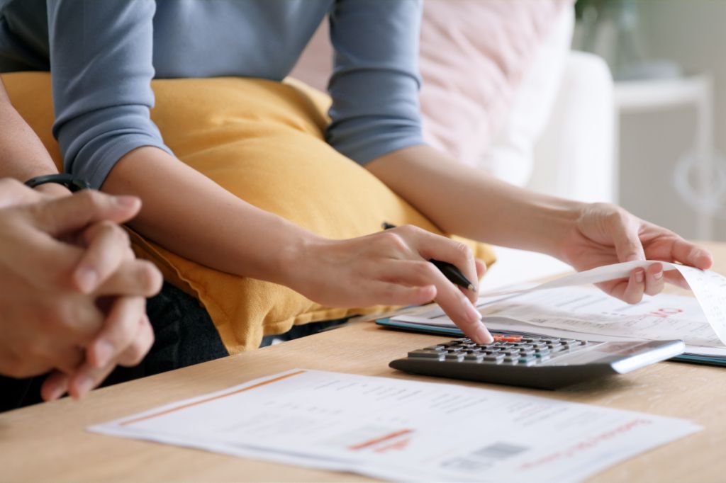 Hands of a woman calculating invoices with a calculator