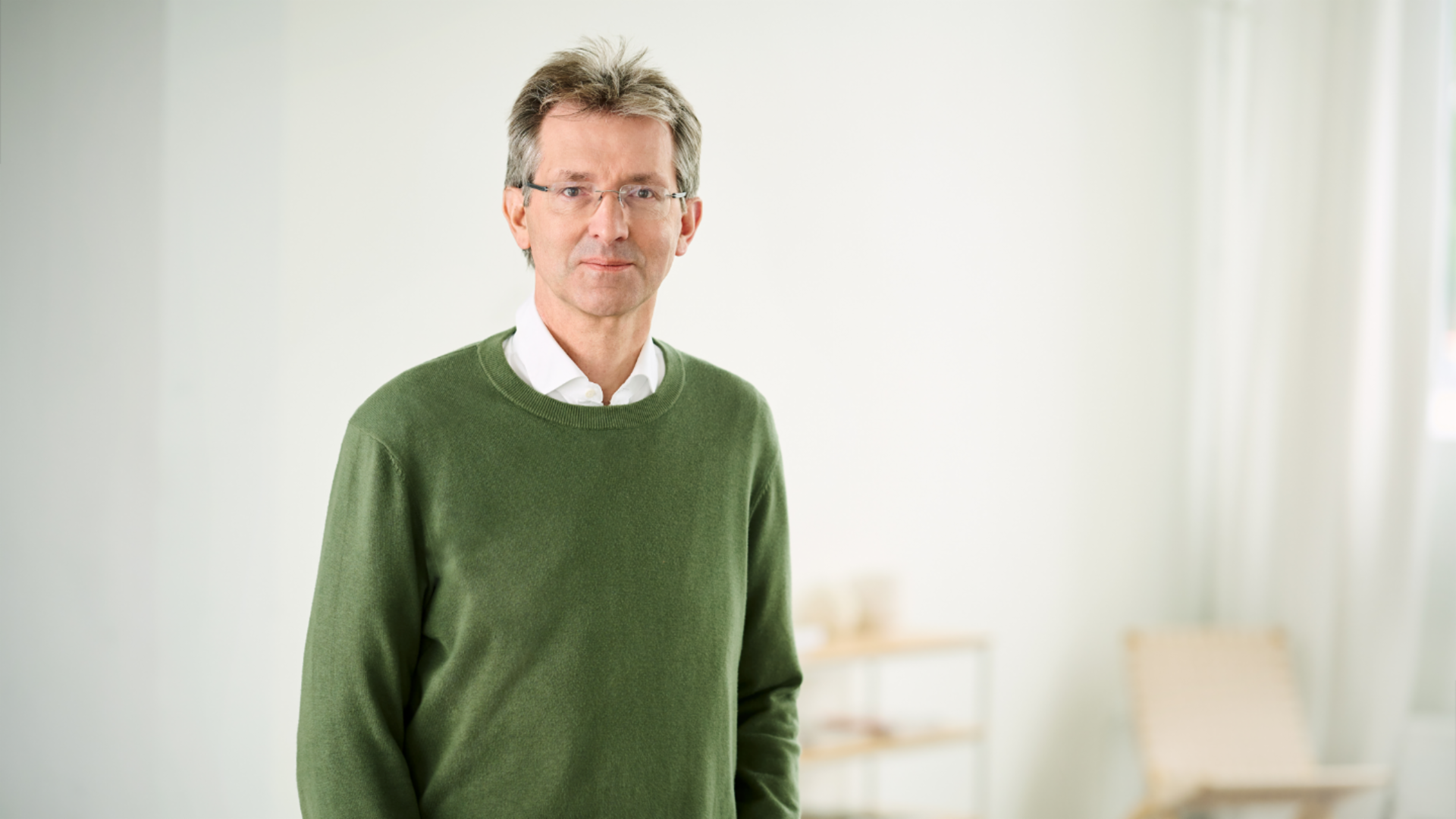 Justus Hecking-Veltman, CFO, cu pulover verde și cămașă albă, stând într-o cameră luminoasă.