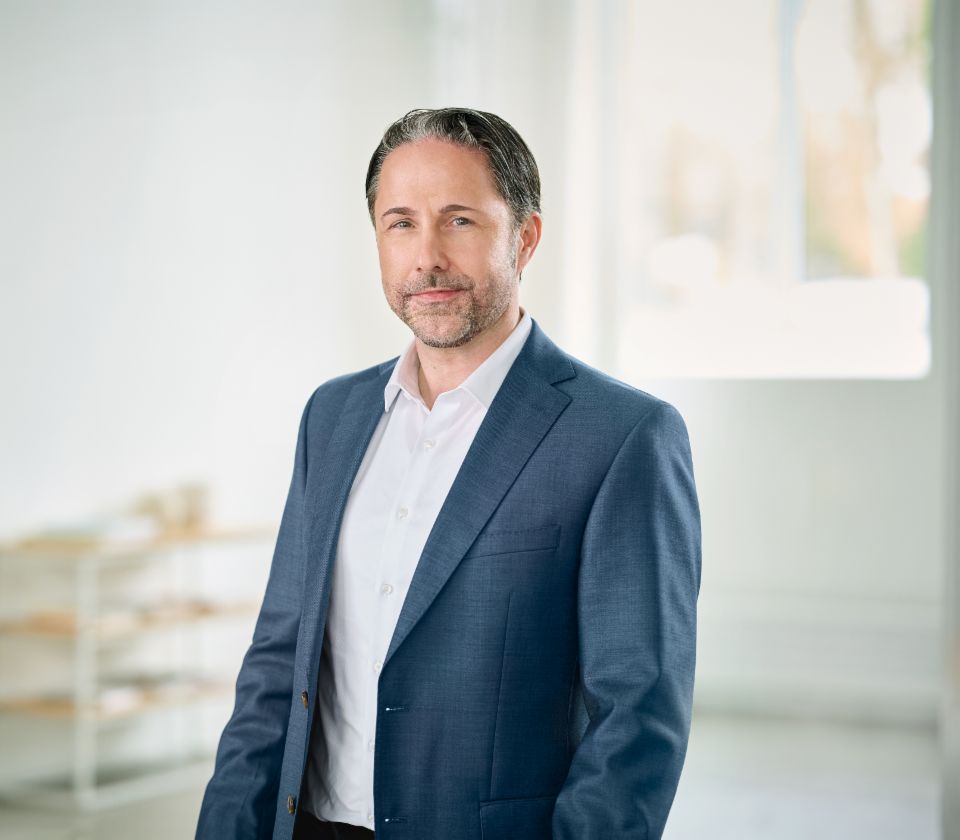 Portretul lui Marwin Ramcke, președintele Bordului Director al Grupului EOS, într-o cameră luminoasă, cu un sacou închis la culoare 